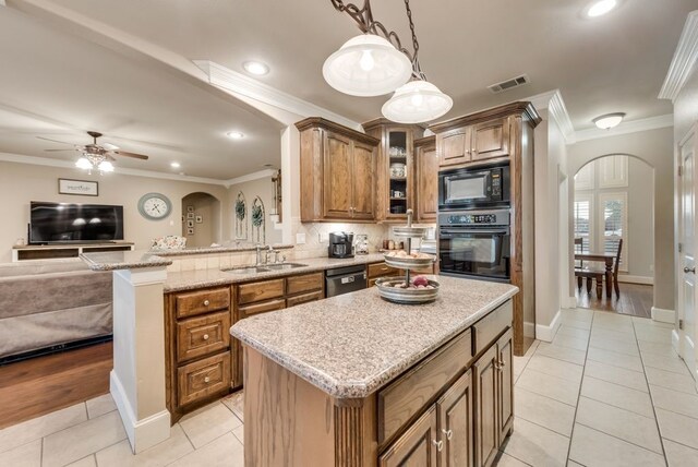 kitchen featuring black appliances, sink, ceiling fan, ornamental molding, and a kitchen island