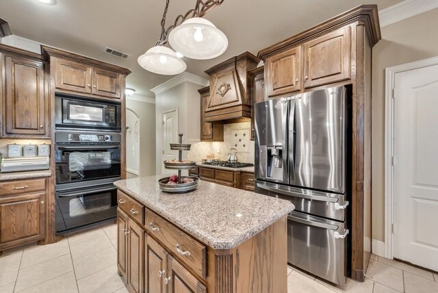 kitchen with a center island, black appliances, tasteful backsplash, decorative light fixtures, and light tile patterned flooring