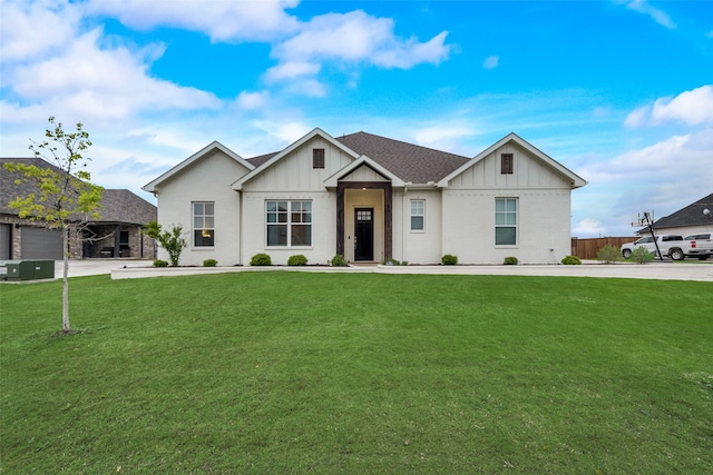 view of front of home featuring central AC unit, a front yard, and a garage