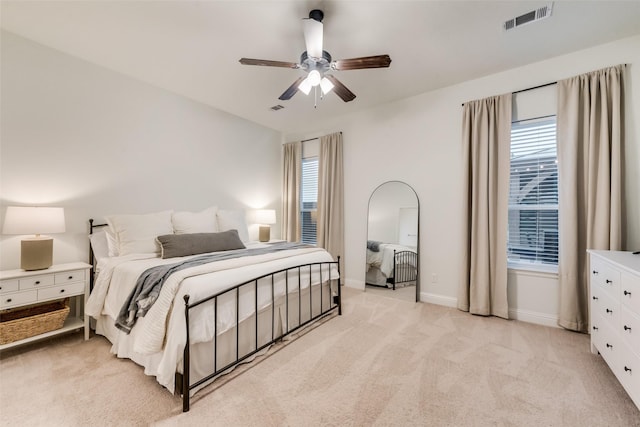 bedroom featuring light carpet, visible vents, a ceiling fan, and baseboards