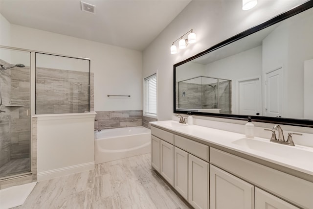 bathroom featuring visible vents, a garden tub, a sink, a shower stall, and double vanity