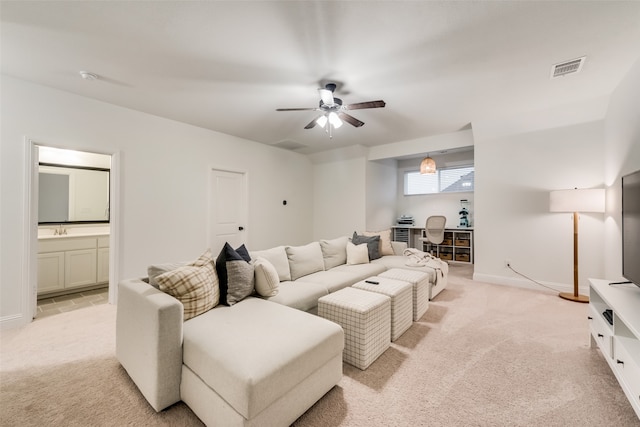 living room featuring ceiling fan, light colored carpet, and sink