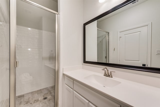 bathroom with walk in shower and vanity