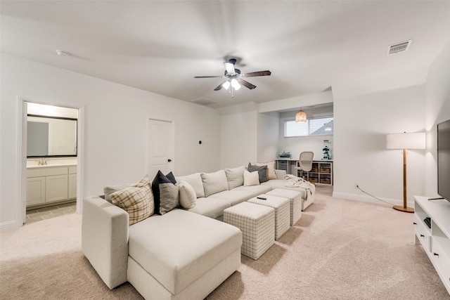 living area featuring light carpet, visible vents, a ceiling fan, and baseboards