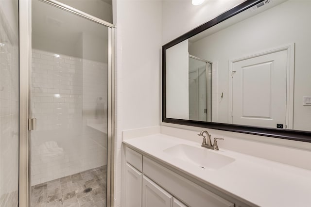 full bath with visible vents, vanity, and a shower stall