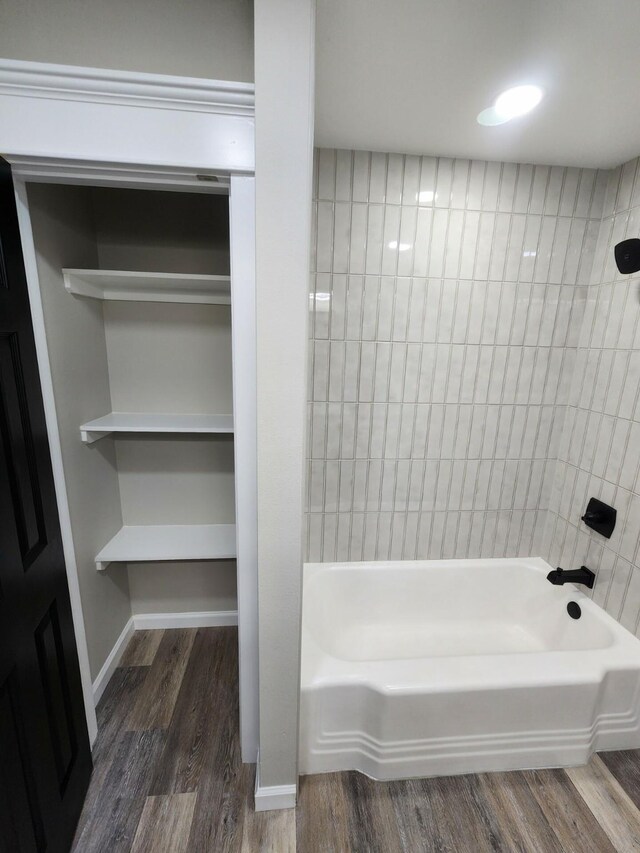 bathroom with tiled shower / bath combo and wood-type flooring