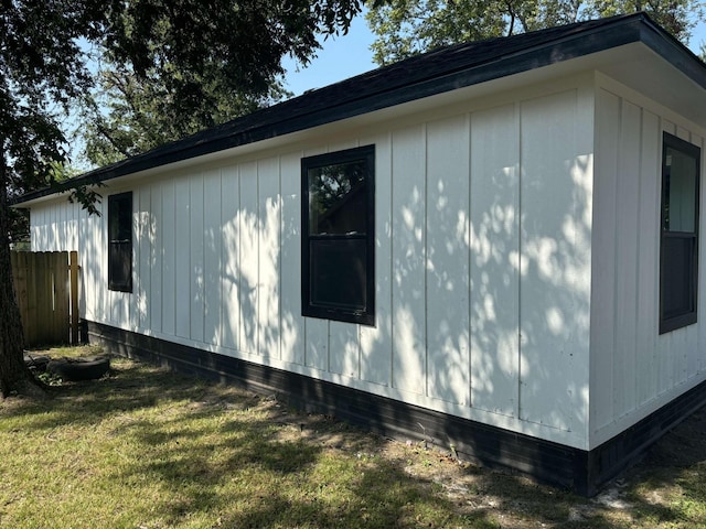 view of side of home featuring an outdoor structure and a lawn