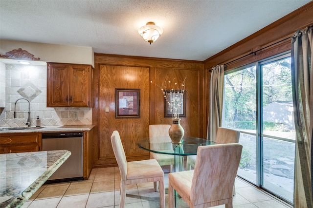 tiled dining room featuring sink and a textured ceiling