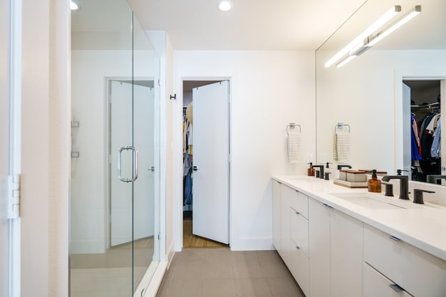 bathroom featuring tile patterned flooring, vanity, and a shower with shower door