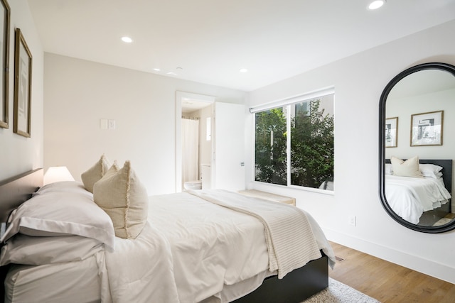 bedroom featuring light wood-type flooring and ensuite bathroom