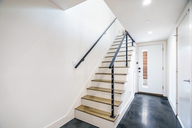 staircase featuring concrete floors