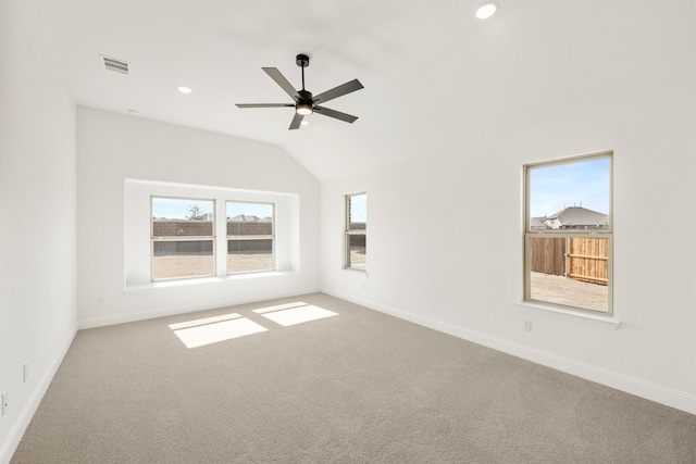 empty room with carpet, visible vents, and a wealth of natural light