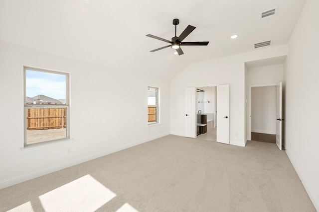 unfurnished bedroom with light carpet, vaulted ceiling, visible vents, and baseboards