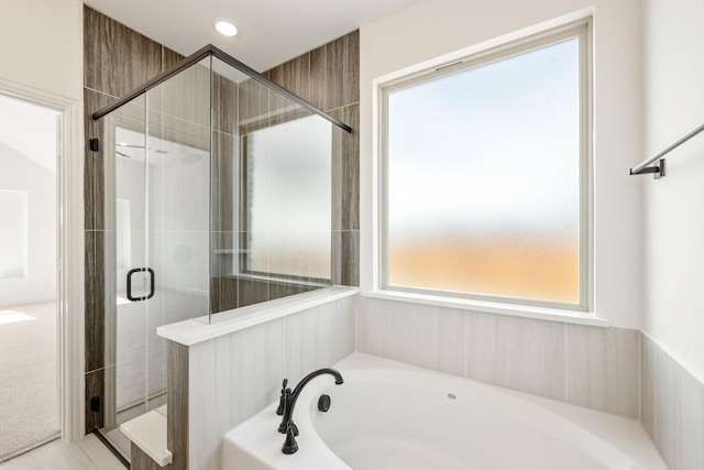 full bath with a stall shower, a bath, and recessed lighting