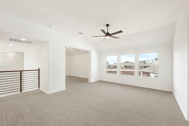 spare room with carpet floors, visible vents, a ceiling fan, and lofted ceiling