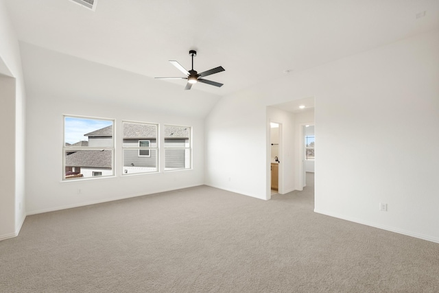 spare room with a ceiling fan, lofted ceiling, a healthy amount of sunlight, and light carpet