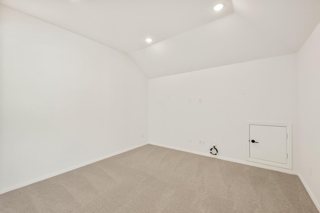 carpeted empty room featuring lofted ceiling, baseboards, and recessed lighting