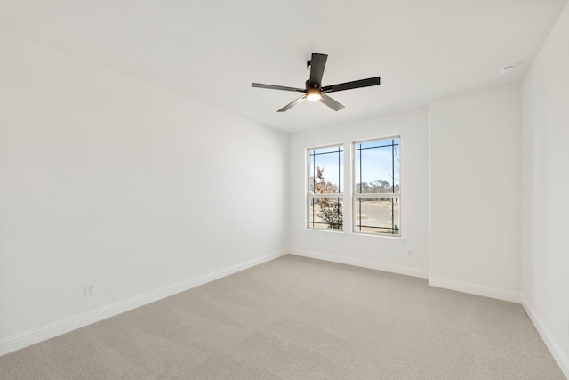 empty room with light carpet, baseboards, and a ceiling fan