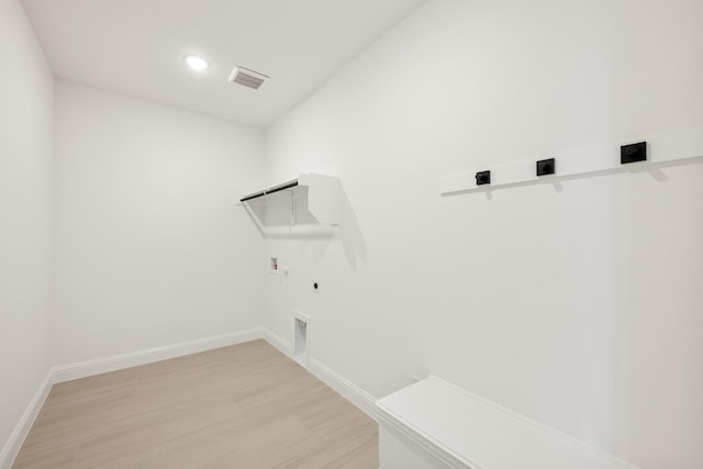 washroom featuring hookup for a gas dryer, laundry area, visible vents, light wood finished floors, and electric dryer hookup