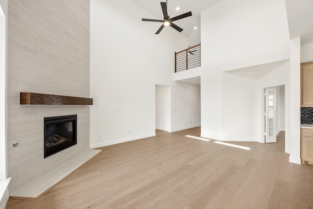 unfurnished living room with ceiling fan, light wood-style flooring, recessed lighting, a fireplace, and baseboards