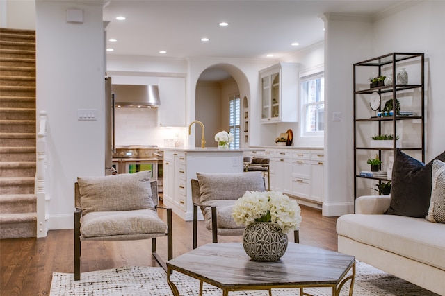 living room featuring hardwood / wood-style floors, sink, and crown molding