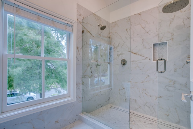 bathroom featuring a shower with door and plenty of natural light