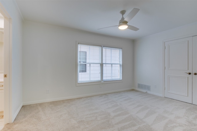 carpeted empty room with ornamental molding and ceiling fan