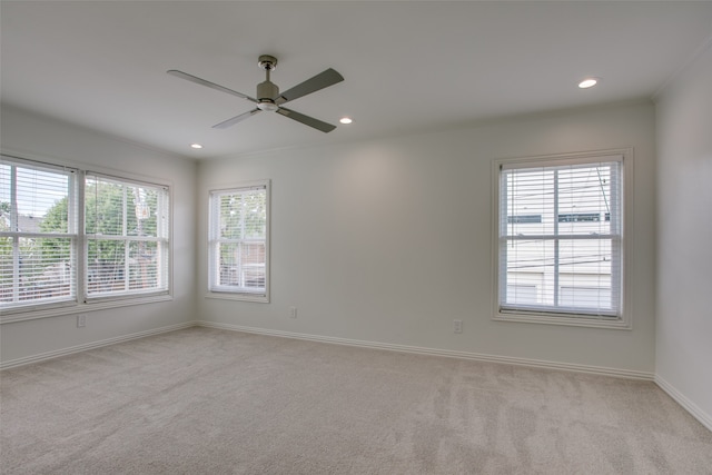 carpeted spare room featuring ceiling fan and ornamental molding