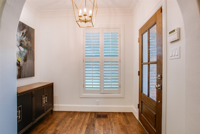 foyer featuring ornamental molding, dark hardwood / wood-style flooring, and an inviting chandelier