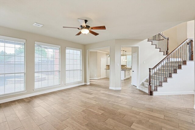 unfurnished living room featuring ceiling fan, light wood-type flooring, and a high end fireplace