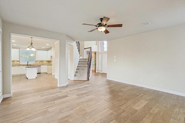 unfurnished living room with ceiling fan and light hardwood / wood-style flooring