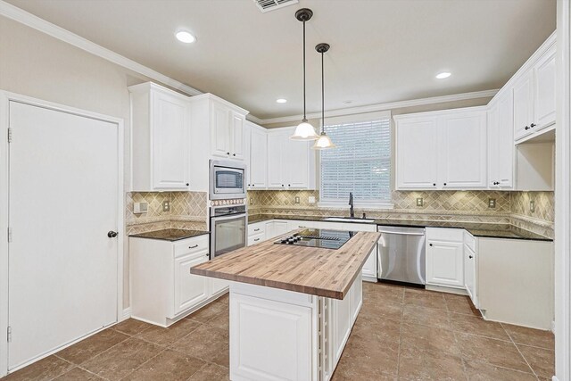 kitchen featuring white cabinetry, butcher block counters, a center island, and sink