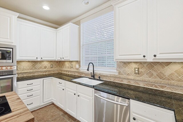 kitchen featuring wood counters, sink, white cabinetry, a center island, and stainless steel appliances