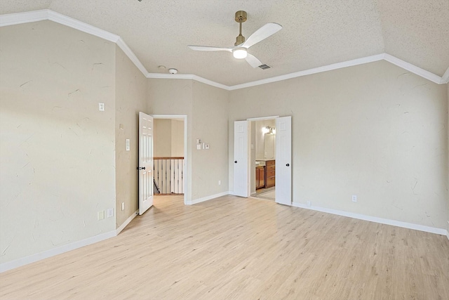 unfurnished room with light wood-style floors, visible vents, vaulted ceiling, and a textured ceiling