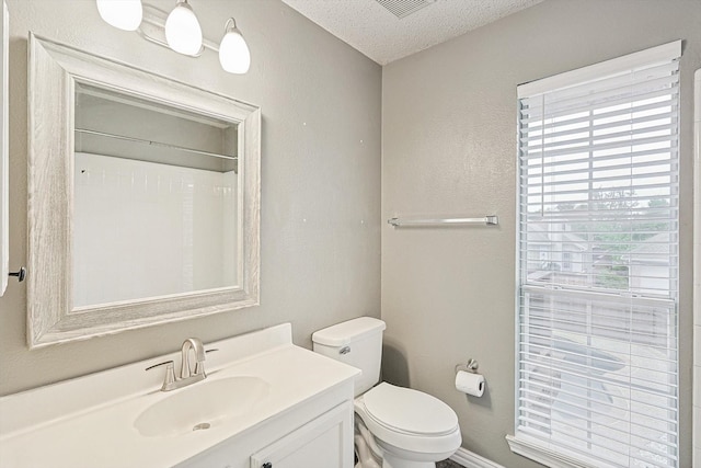 bathroom featuring a textured ceiling, vanity, and toilet