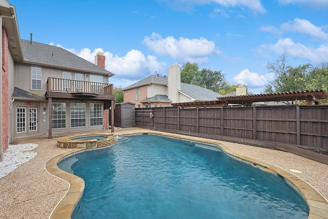 view of pool featuring an outbuilding, a patio, a pool with connected hot tub, a shed, and a fenced backyard