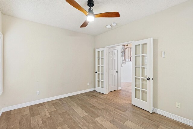 unfurnished room featuring a textured ceiling, light hardwood / wood-style flooring, and ceiling fan