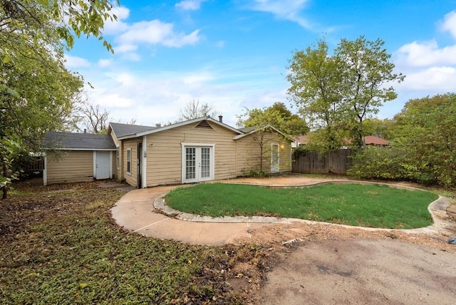 back of property featuring french doors, a patio, and a yard