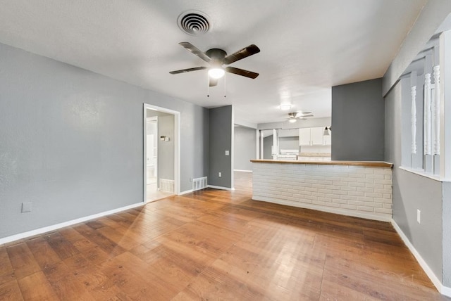 unfurnished living room with hardwood / wood-style floors and ceiling fan