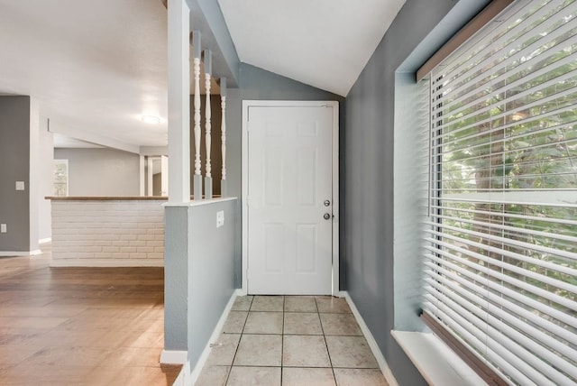 entryway with lofted ceiling and light tile patterned floors