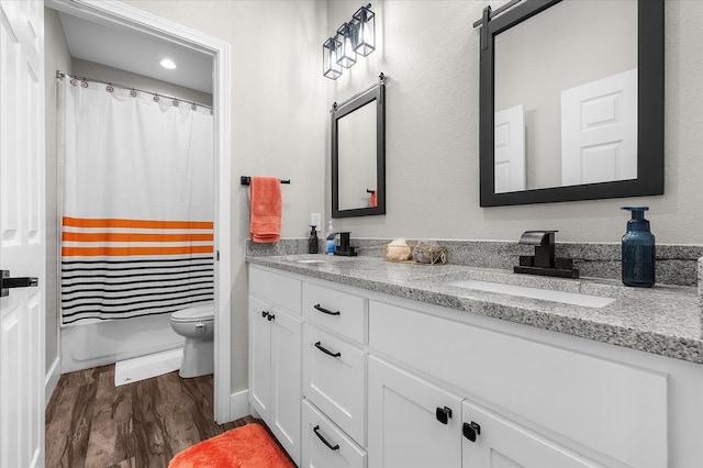 full bathroom featuring hardwood / wood-style flooring, vanity, toilet, and shower / tub combo