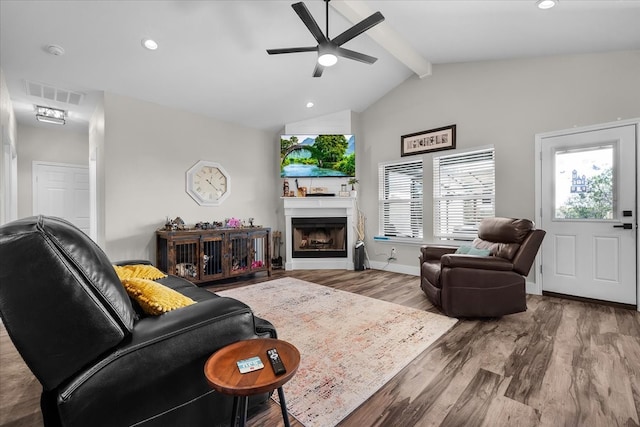 living room with hardwood / wood-style floors, beamed ceiling, ceiling fan, and high vaulted ceiling