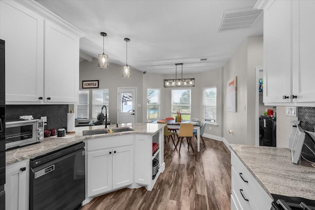 kitchen with white cabinetry, sink, light stone countertops, hardwood / wood-style floors, and black dishwasher