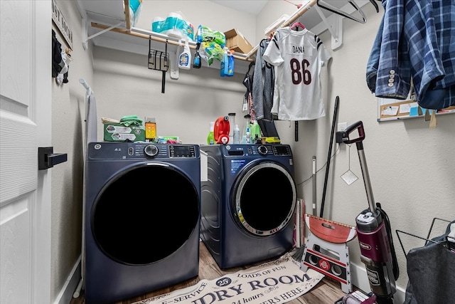 laundry area with independent washer and dryer and wood-type flooring