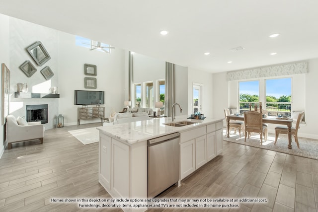 kitchen featuring light hardwood / wood-style floors, a center island with sink, sink, white cabinets, and dishwasher