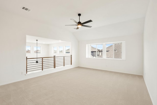 carpeted empty room featuring ceiling fan, lofted ceiling, visible vents, and baseboards