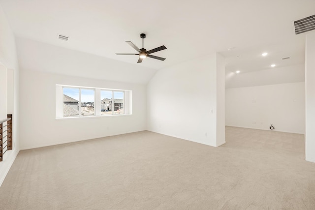 empty room with visible vents, vaulted ceiling, light carpet, and ceiling fan