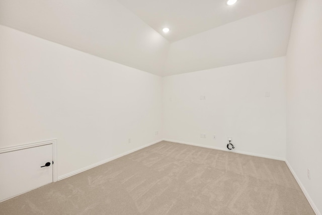 unfurnished room featuring recessed lighting, light carpet, lofted ceiling, and baseboards