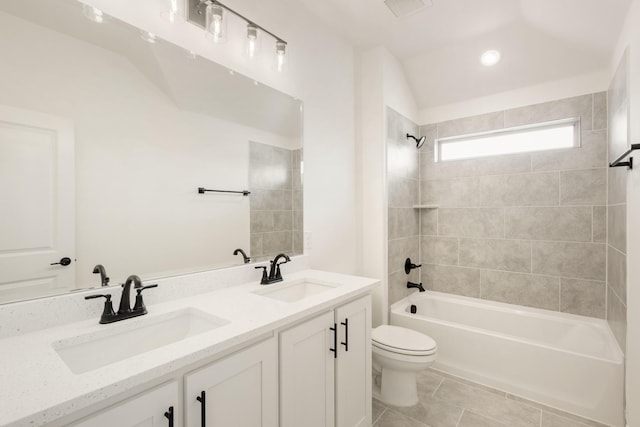 bathroom featuring tile patterned flooring, tub / shower combination, a sink, and toilet