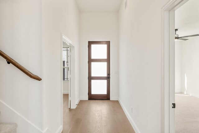 living room featuring a towering ceiling, plenty of natural light, and light hardwood / wood-style floors